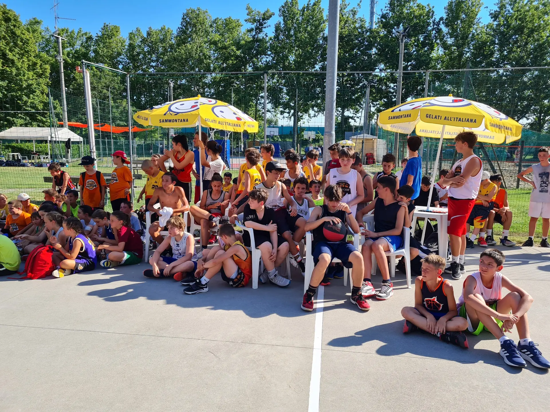I ragazzi del day camp di Forlì seduti sul campo all'aperto